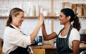Shot of two women giving each other a high five because they're saving time with a chatbot for their business